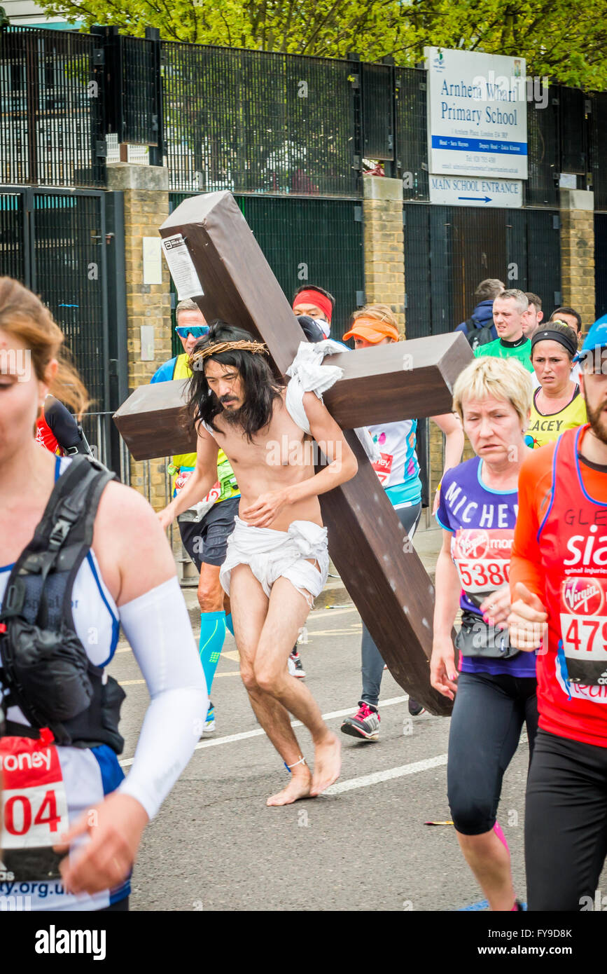 London, UK. 24th April, 2016. London Marathon 2016. Runners in great costumes.  Barefoot runner as Jesus with a cross on his back Credit:  Elena Chaykina/Alamy Live News Stock Photo