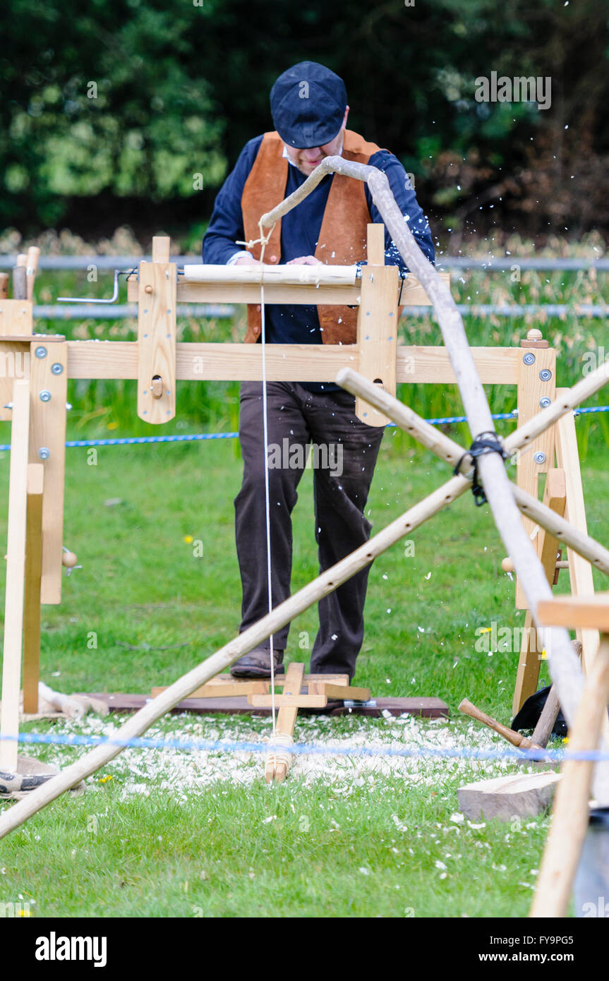 A woodworking craftsman uses a footpowered manual lathe to turn a