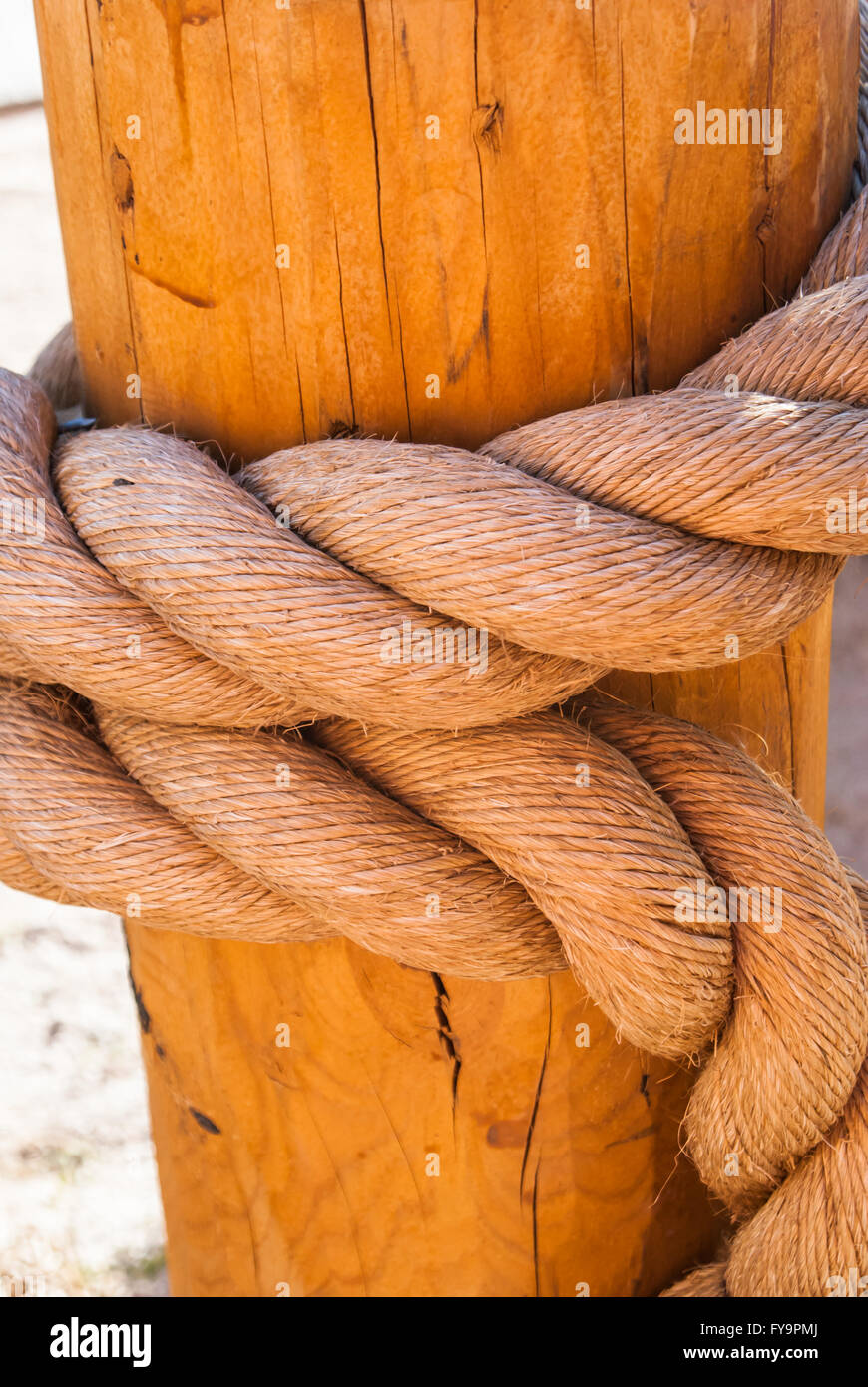 Large nautical rope tied on wooden post Stock Photo - Alamy