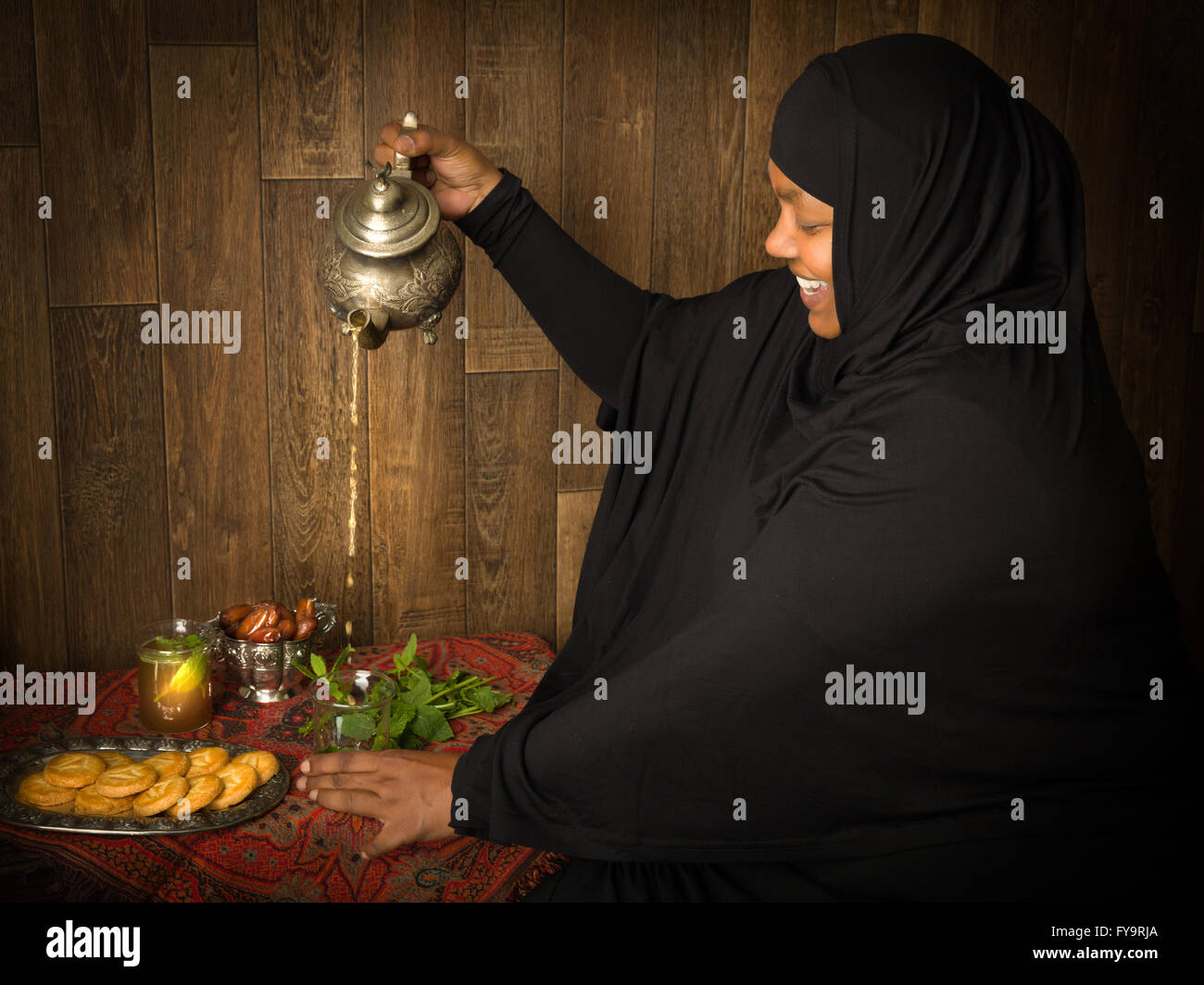 Smiling muslim woman pouring mint tea the traditional way Stock Photo ...