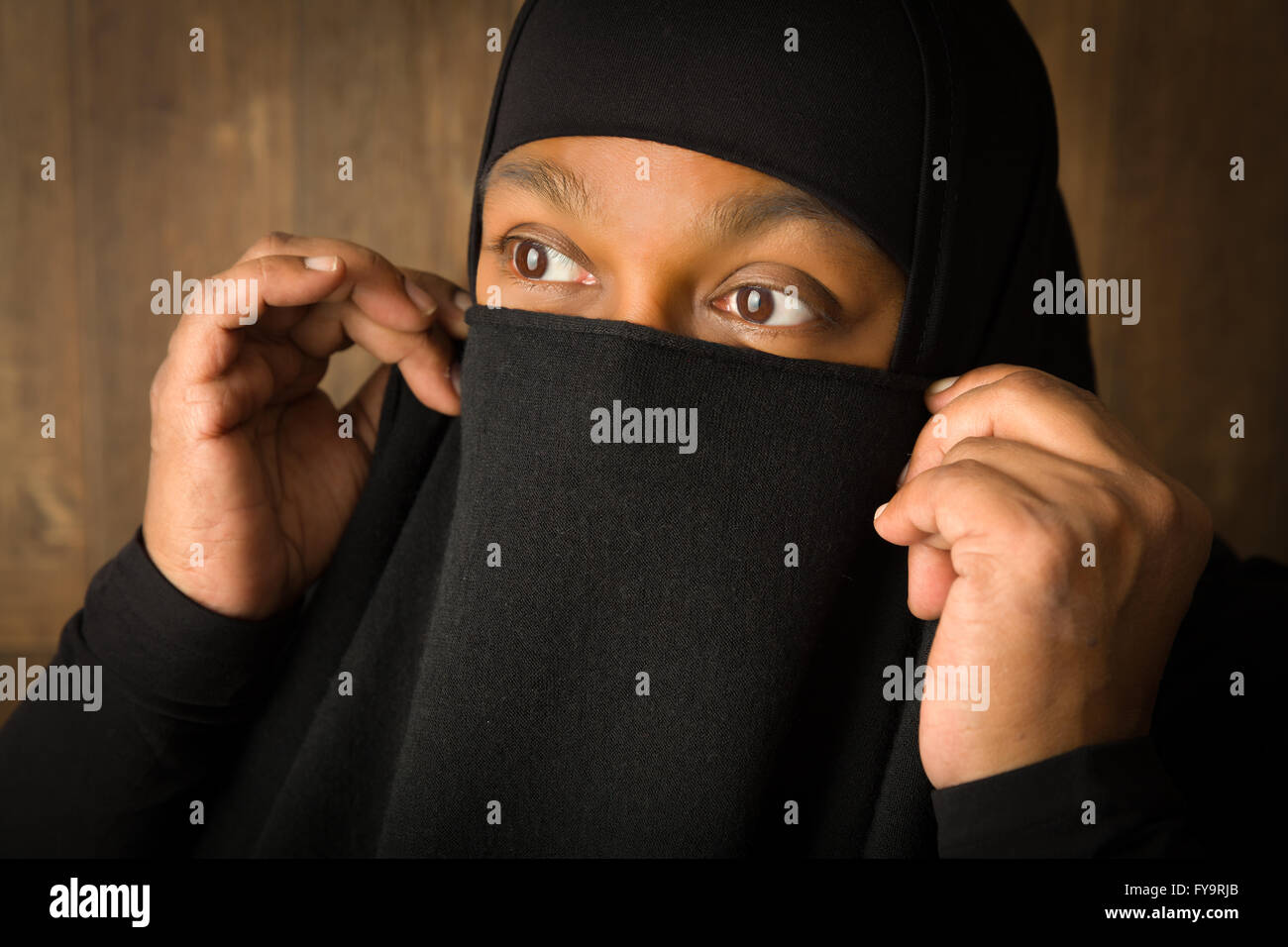 African islam woman hiding behind a black veil Stock Photo