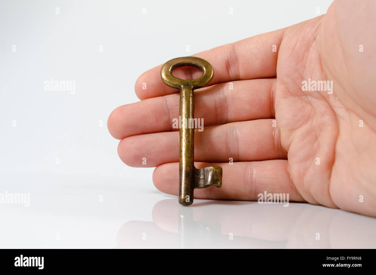 Hand holding key on isolated on white background Stock Photo - Alamy