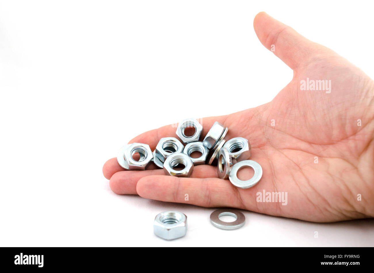 Several metal screw washers and nuts in human hand isolated on white