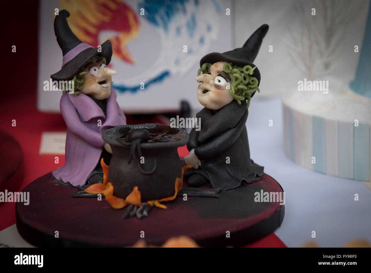 Halloween two witches by the cauldron at Cake International – The Sugarcraft, Cake Decorating and Baking Show in London Stock Photo