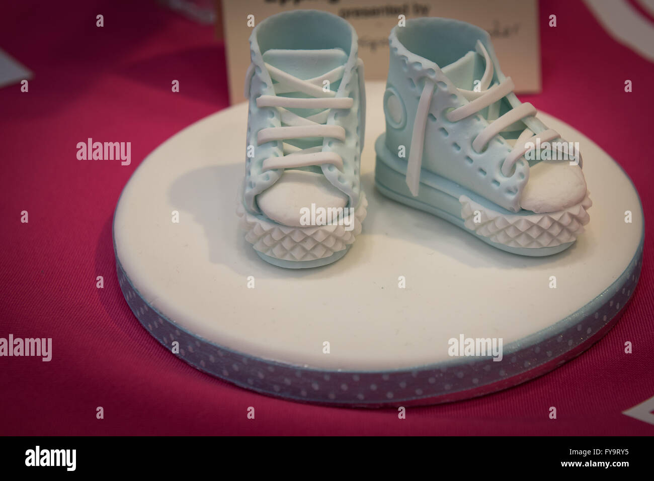 Baby shower cake boy blue shoes edible at Cake International – The Sugarcraft, Cake Decorating and Baking Show in London. Stock Photo