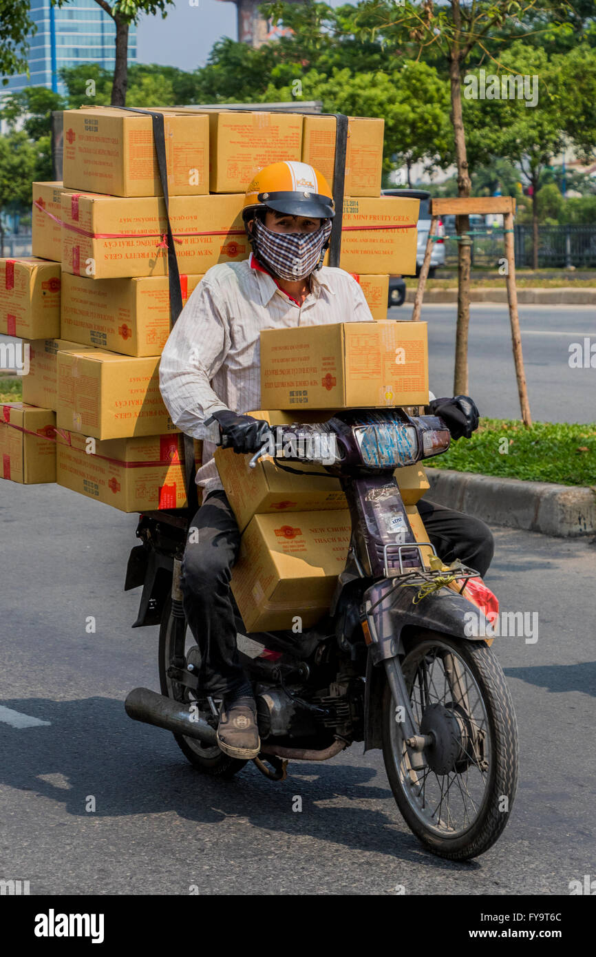 Trader in Ho Chi Minh city Vietnam on small motorcycles are the biggest road users in Vietnam Stock Photo