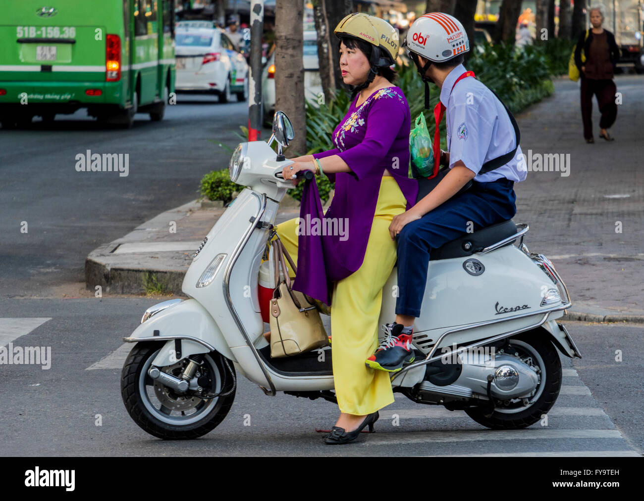 Lady in HoChi Minh city Vietnam on motor scooter wearing Vietnamese Ao