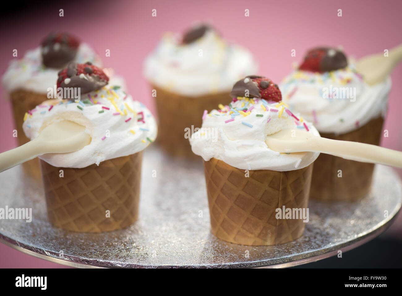 Vanilla ice cream cone with sprinkle cupcakes at Cake International – The Sugarcraft, Cake Decorating and Baking Show in London. Stock Photo