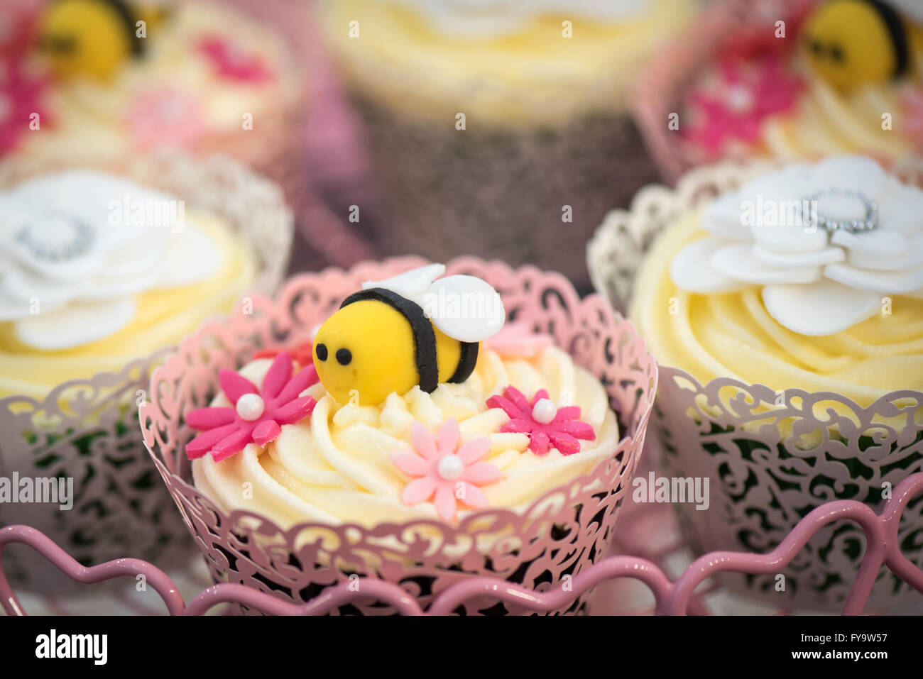 Honey bee and flowers cupcakes at Cake International – The Sugarcraft, Cake Decorating and Baking Show in London Stock Photo