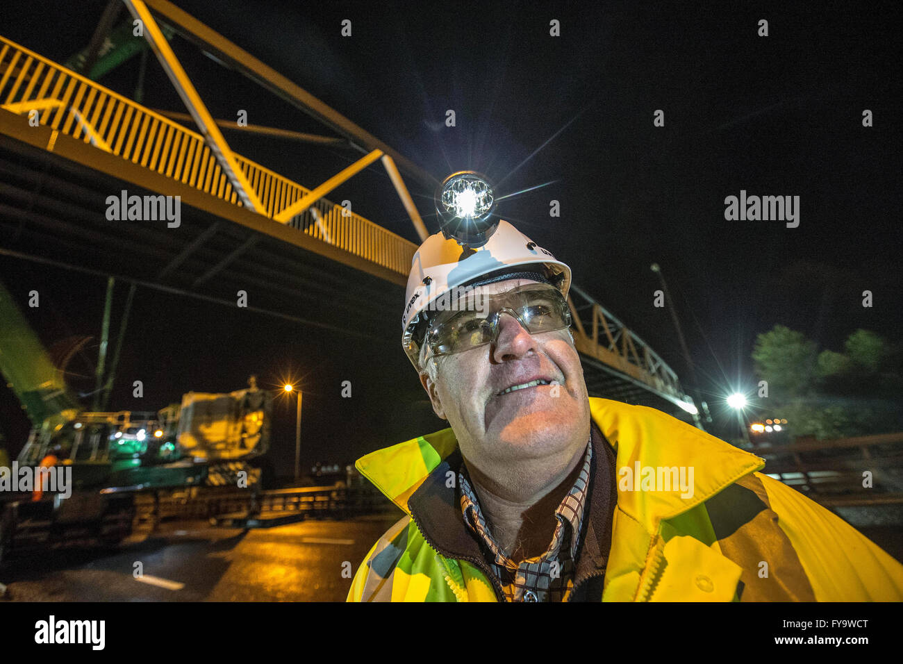 Footbridge being lifted in at night by crane Stock Photo