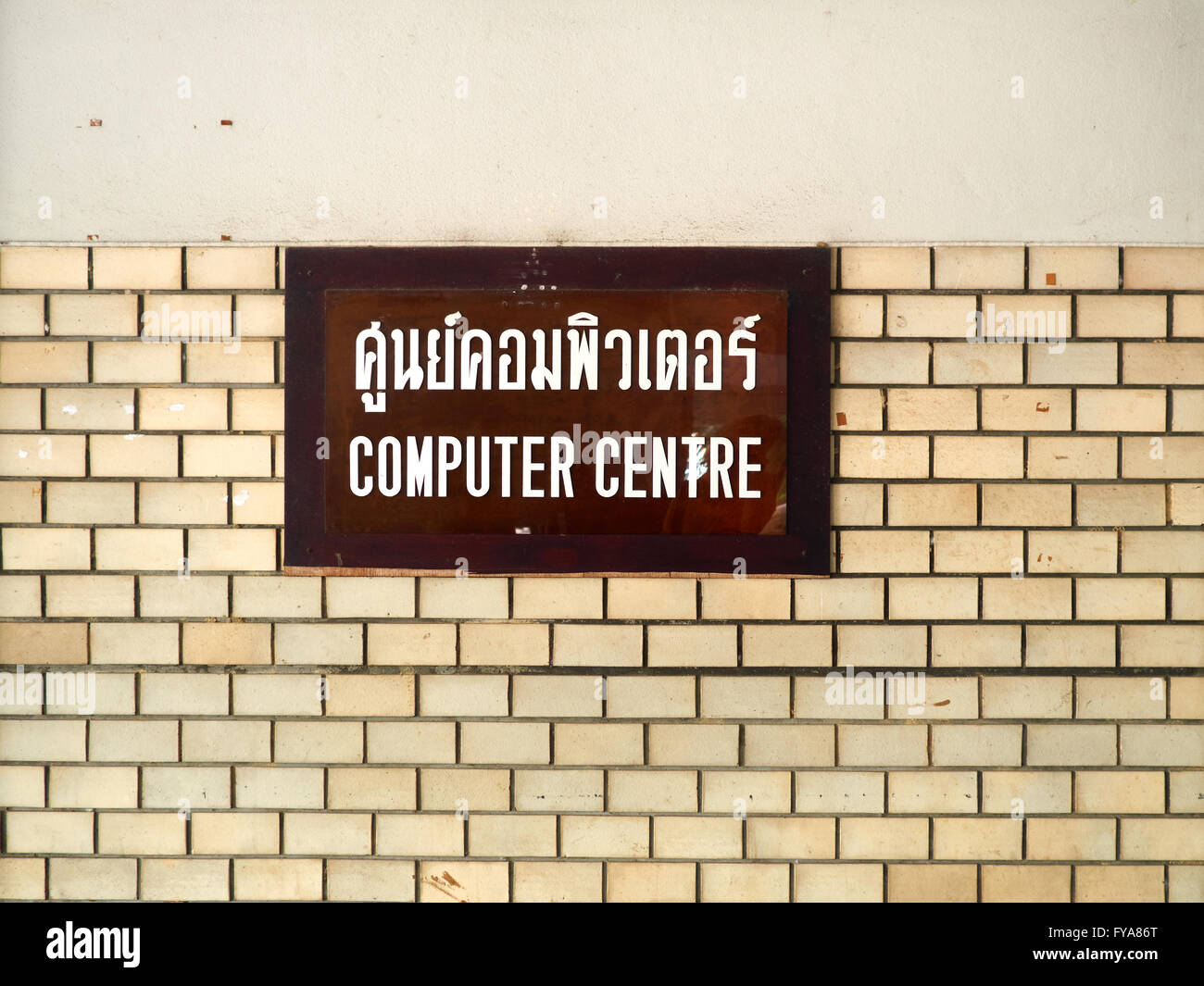 A brown computer centre sign mounted on a brick pattern wall. Stock Photo