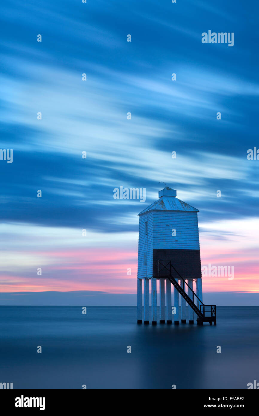 The lighthouse at Burnham-on-sea, Somerset, stands silhouetted against a pink and blue sky at sunset. Stock Photo