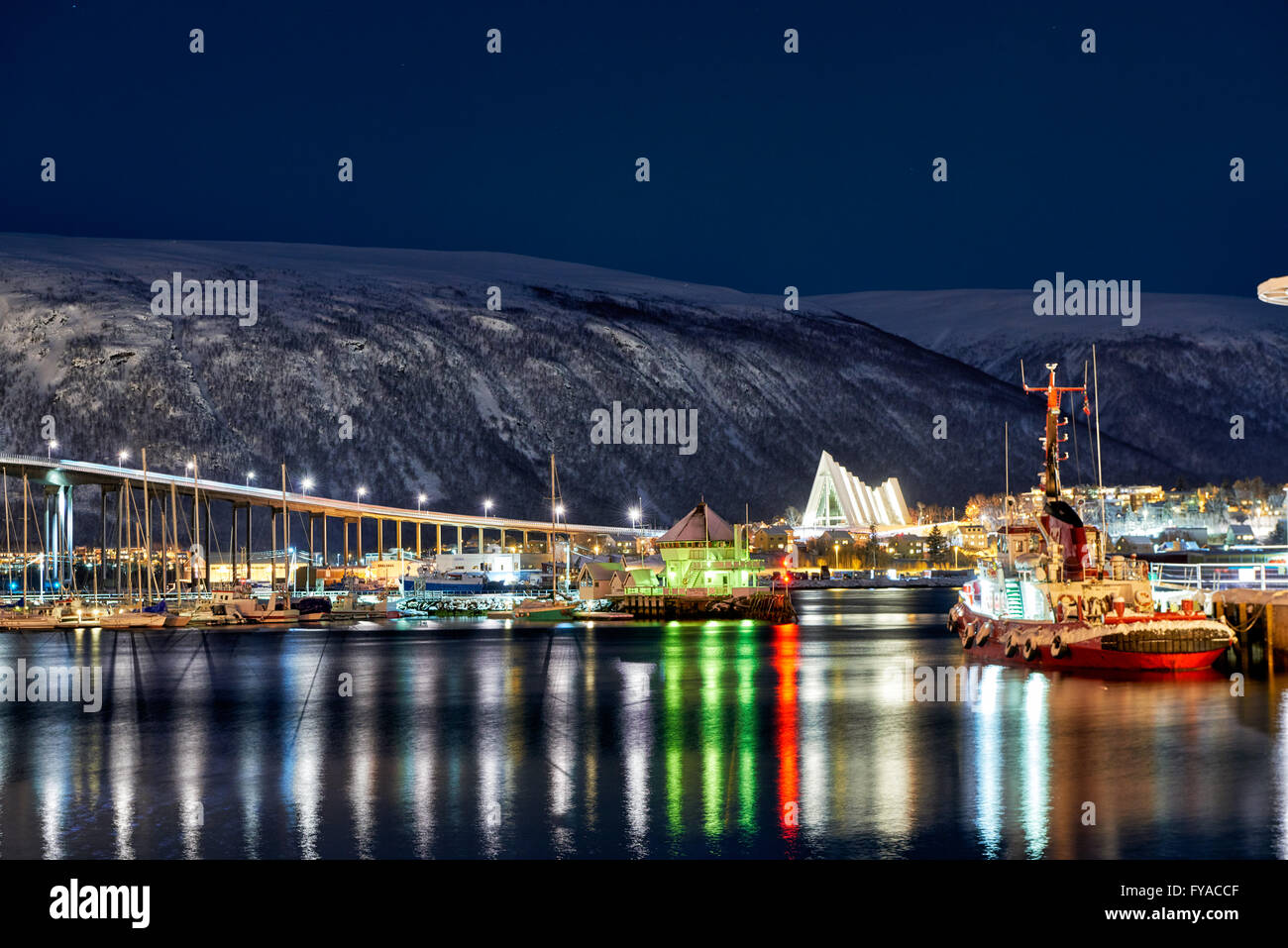 night shot of snow covered landscape of harbour and Arctic Cathedral in Tromsø, Troms, Norway, Europe Stock Photo
