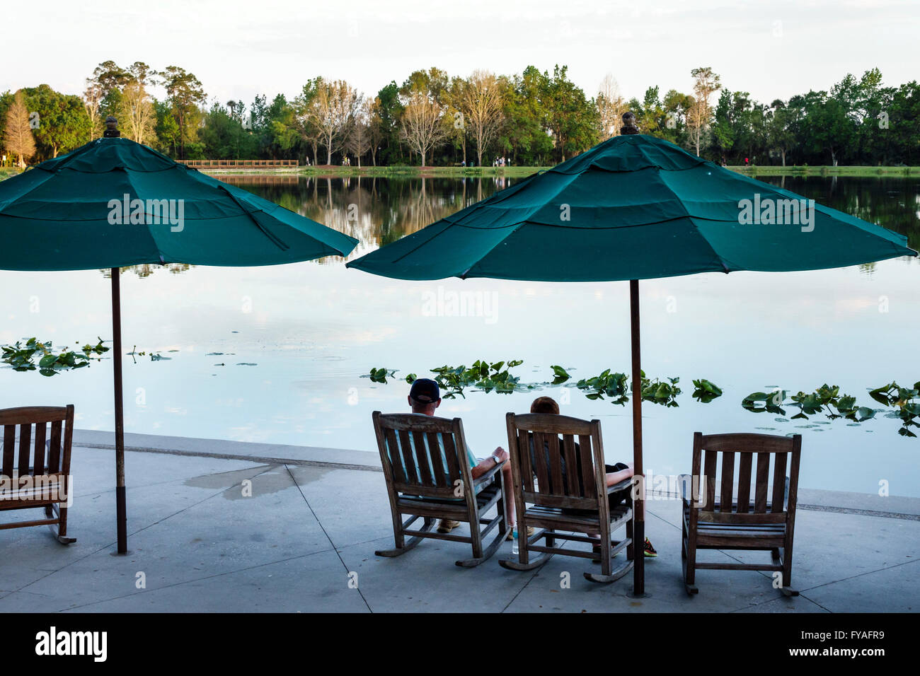 Orlando Florida,master-planned community,neo-urbanism,downtown,Front Street,Lake Rianhard,rocking chairs,umbrellas,scenery,water,couple,relaxing,Town Stock Photo