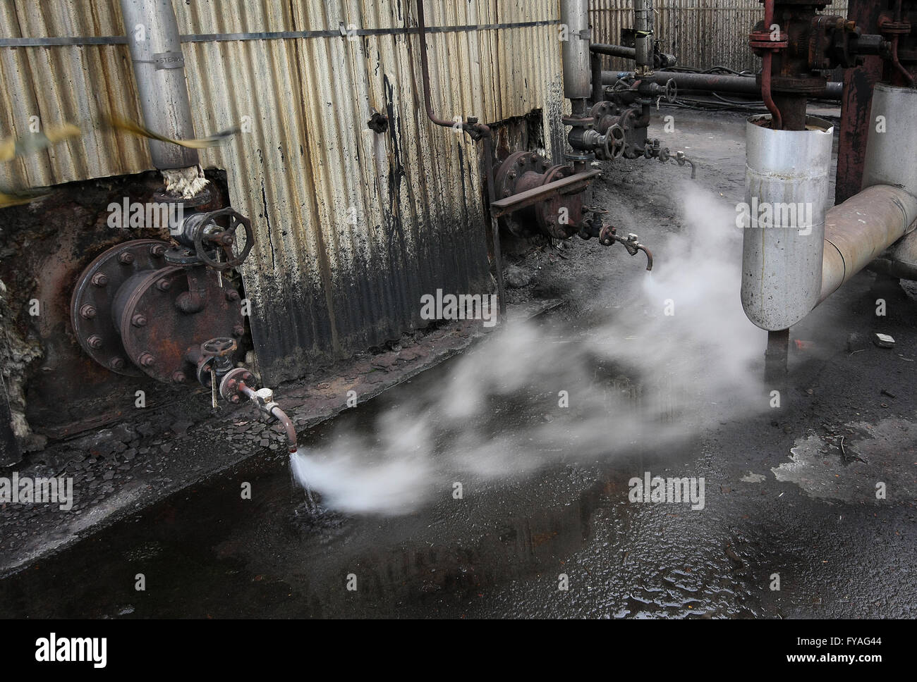 Steam from condensate trap on storage tank. Stock Photo
