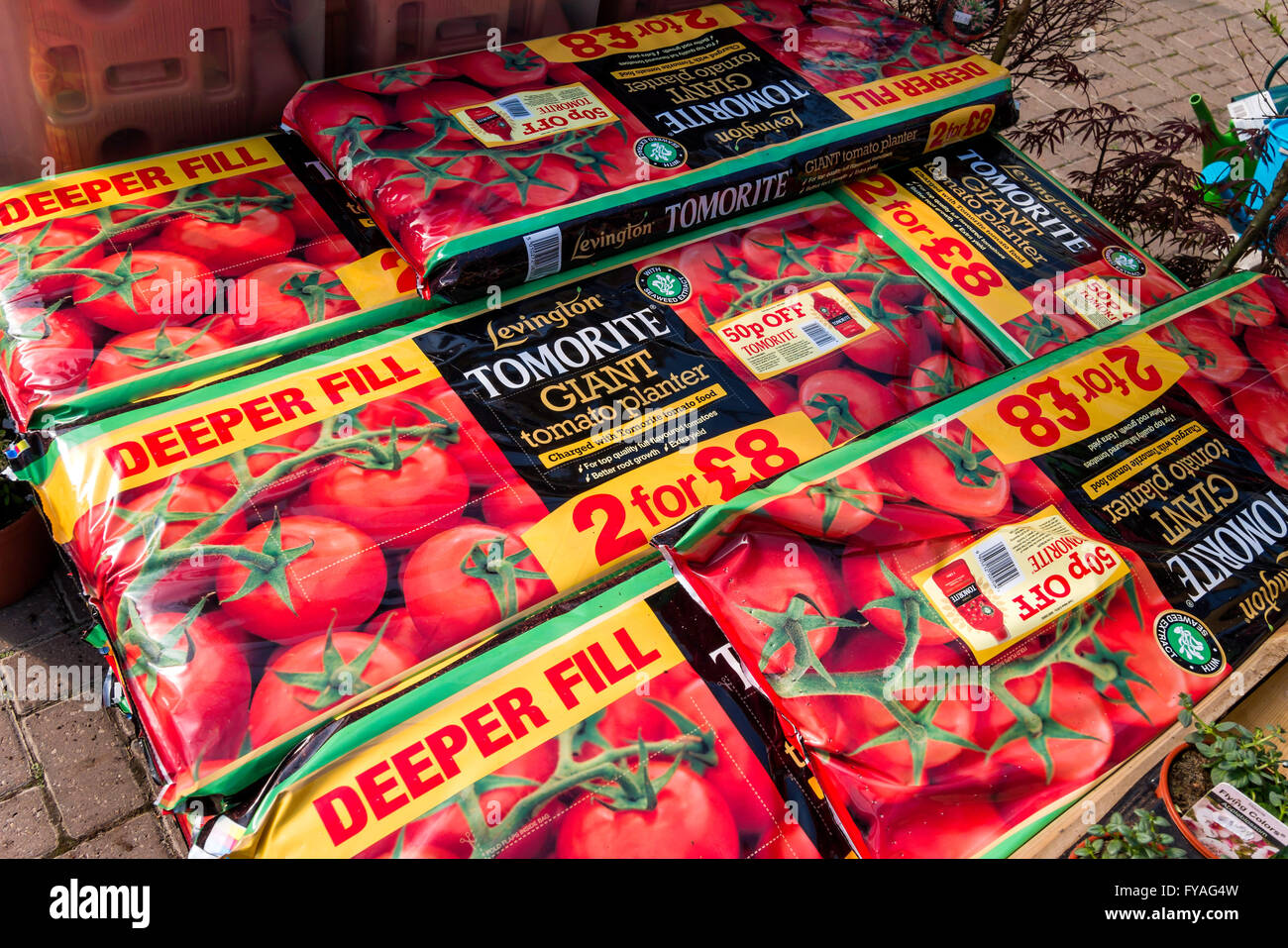A stack of extra large red grow bags in a garden centre used for growing tomato plants Stock Photo