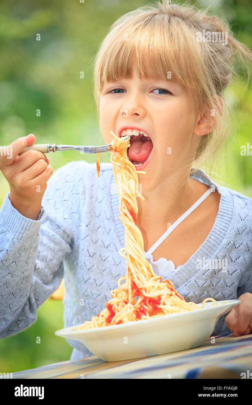 girl eating spaghetti in the garden Stock Photo Alamy