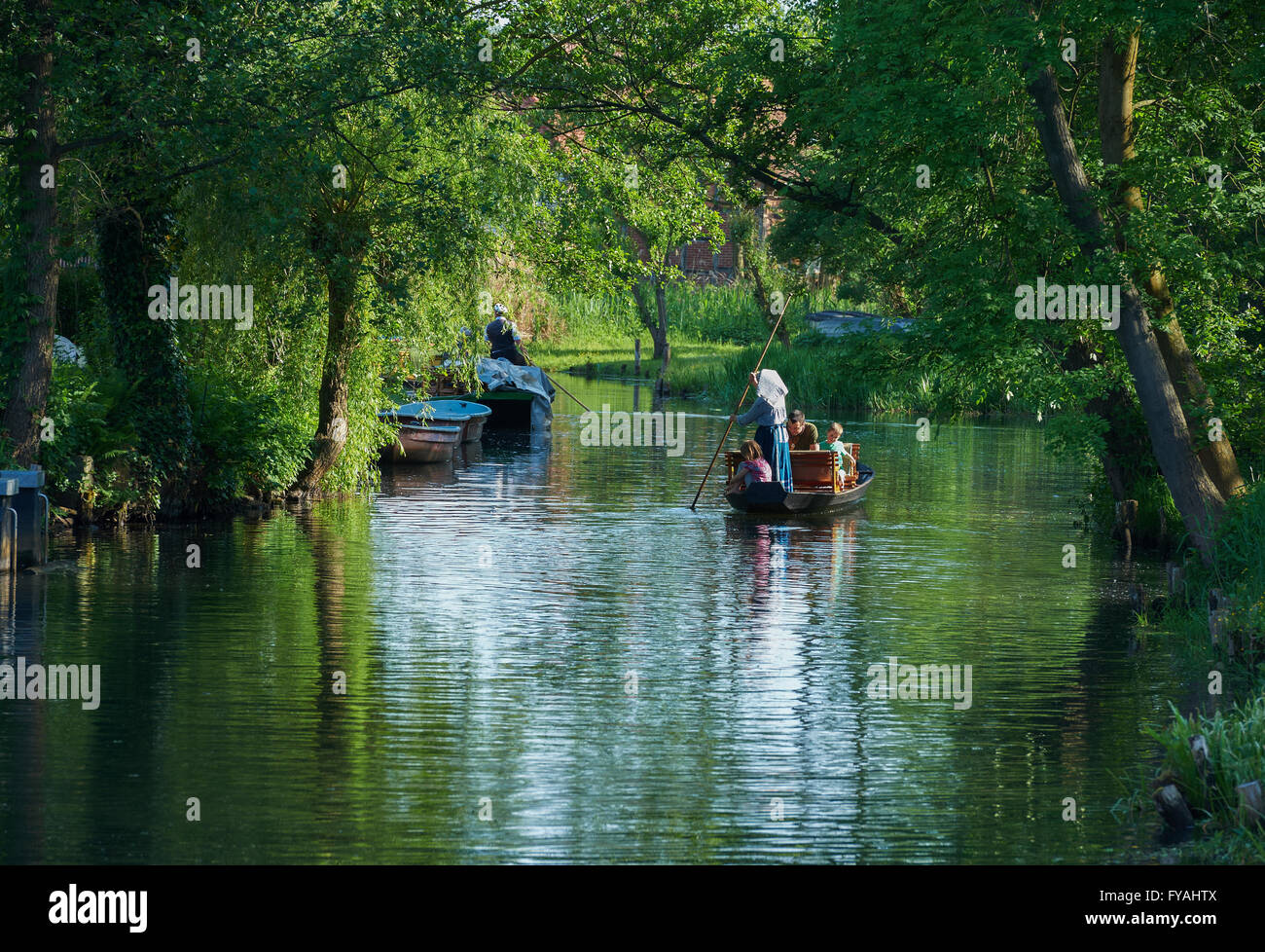 GERMANY, BRANDENBURG, SPREEWALD Woman in traditional dress poling a tourist boat through the spreewald channels at Schlepzig Stock Photo