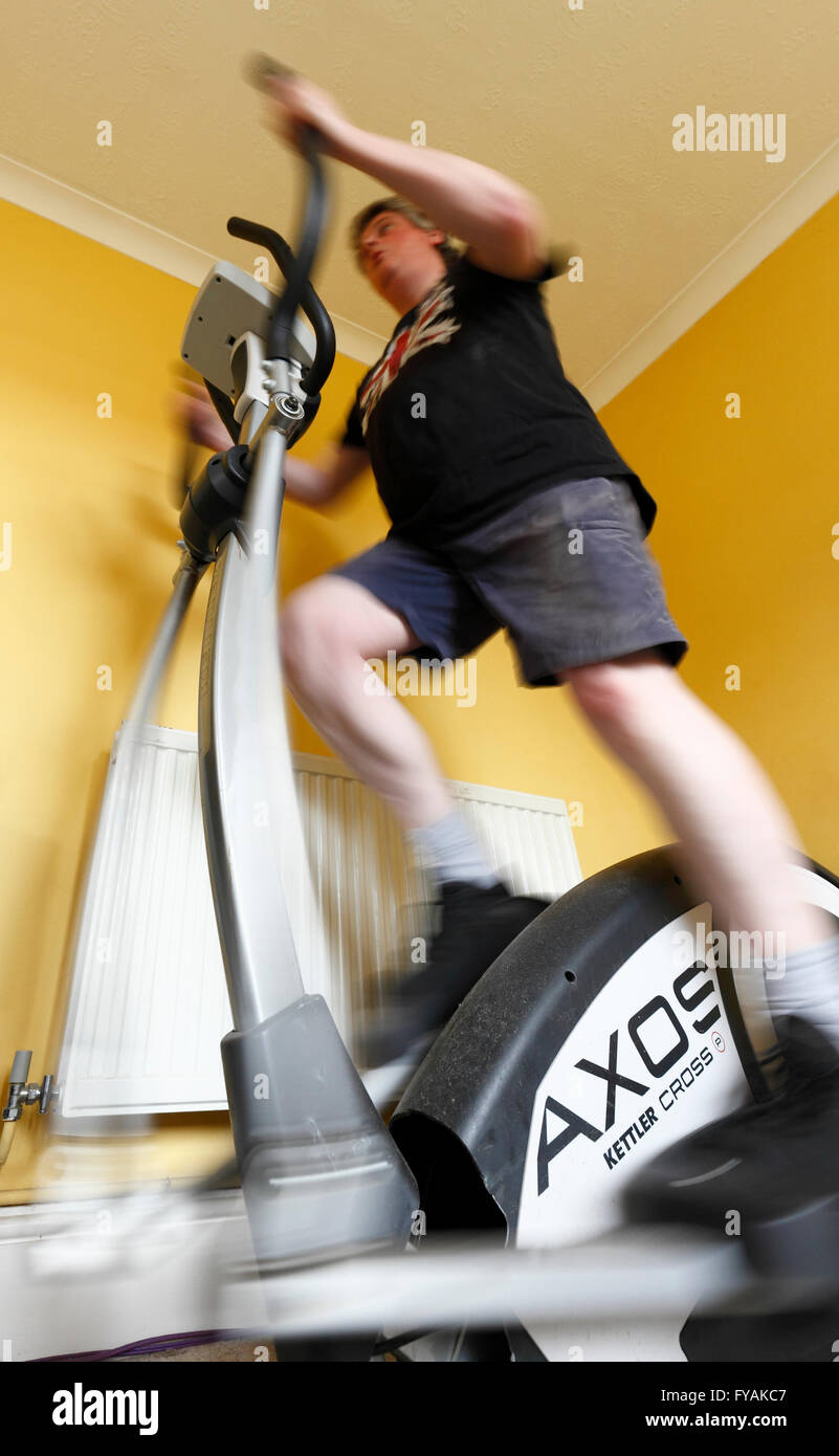 Middle age man using a crosstrainer exercise machine. Stock Photo
