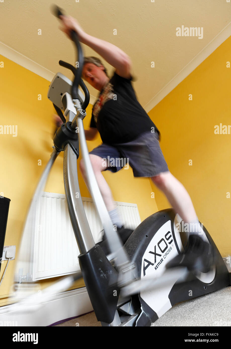 Middle age man using a crosstrainer exercise machine. Stock Photo