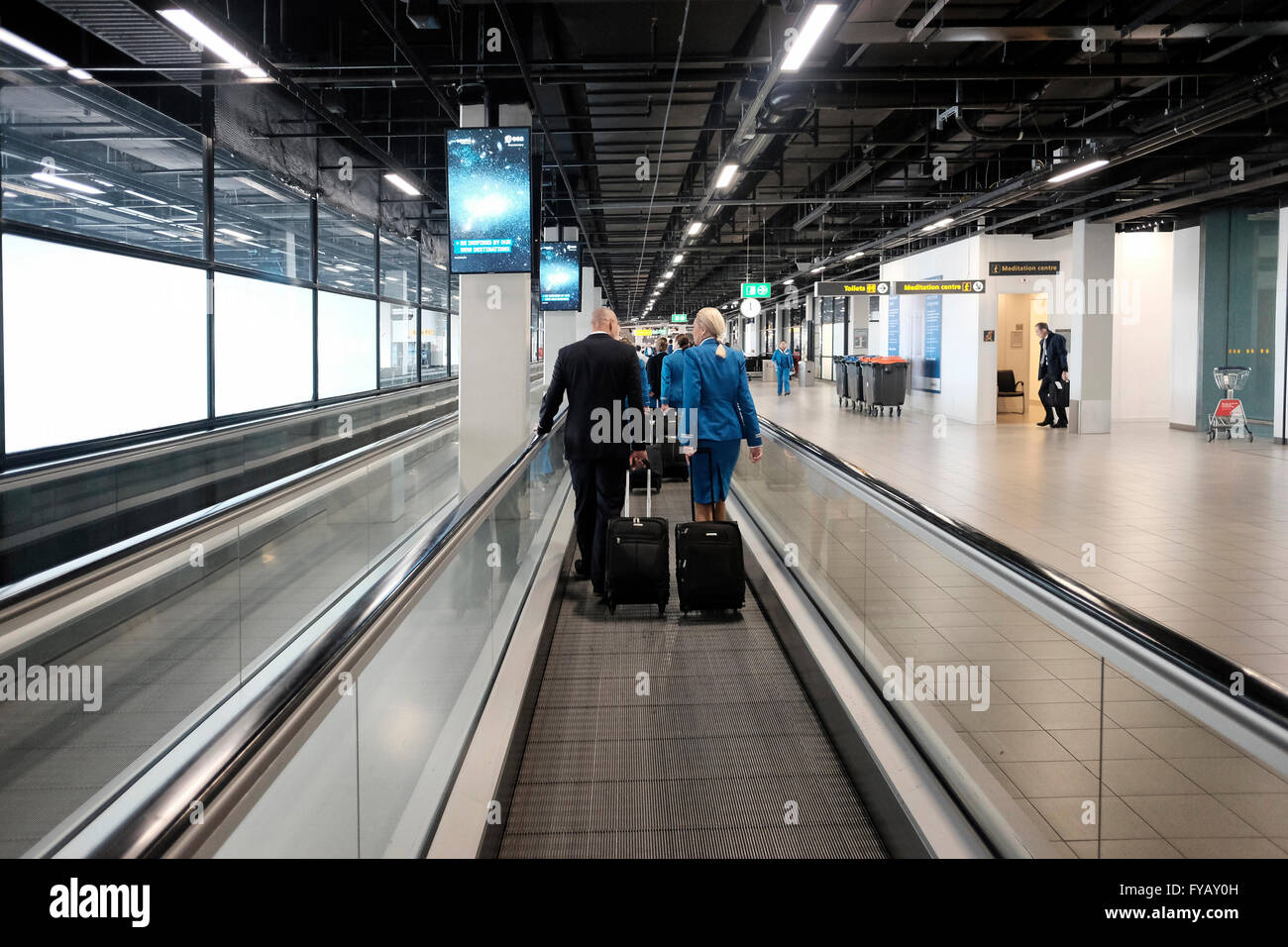 KLM cabin crew at the moving walkways in Schiphol airport in Amsterdam Netherlands Stock Photo