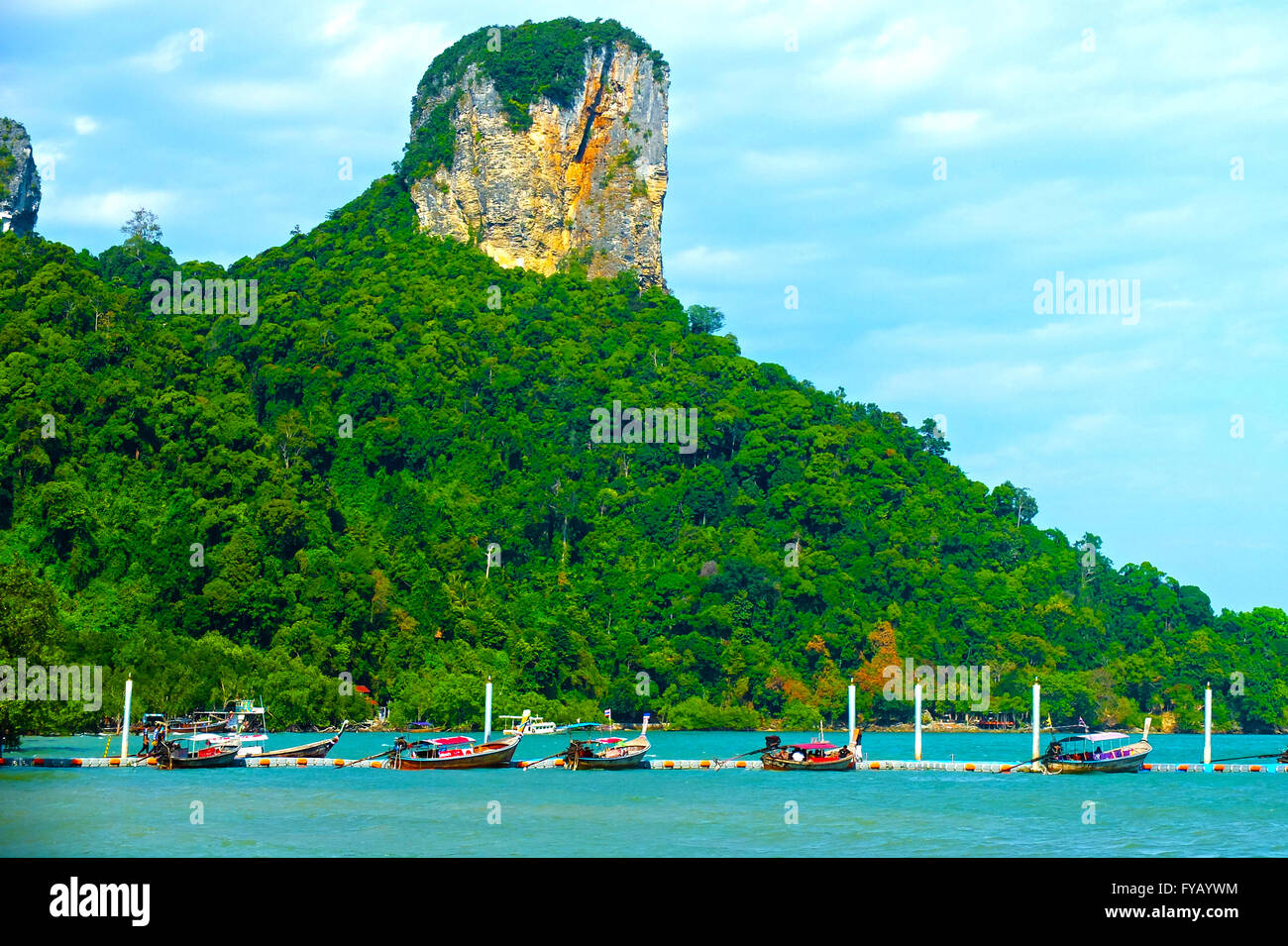 Limestone cliffs with Thai long tail boats anchored along the floating pier Stock Photo