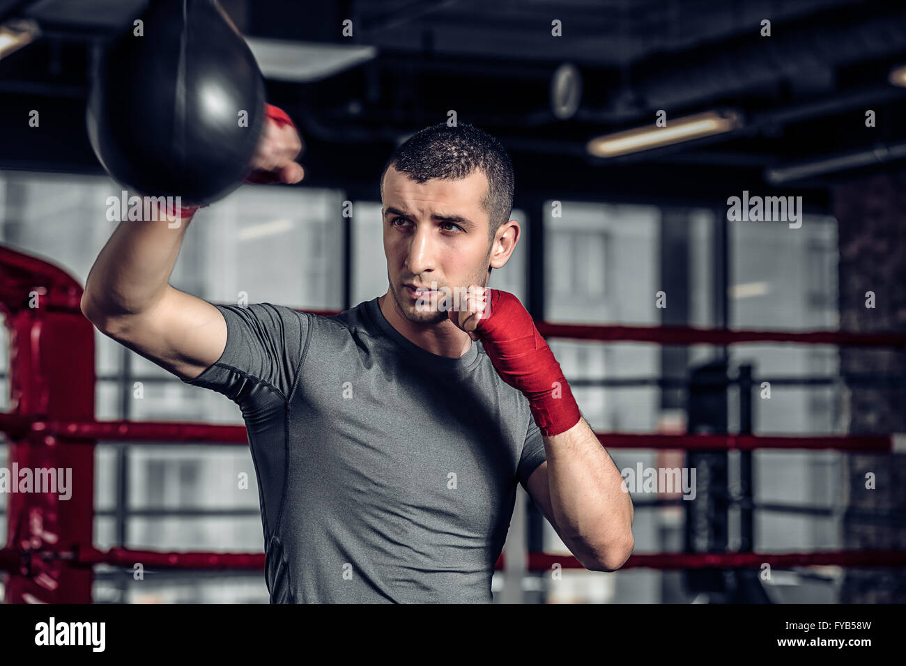 Male boxer using a punching bag in gym Stock Photo Alamy