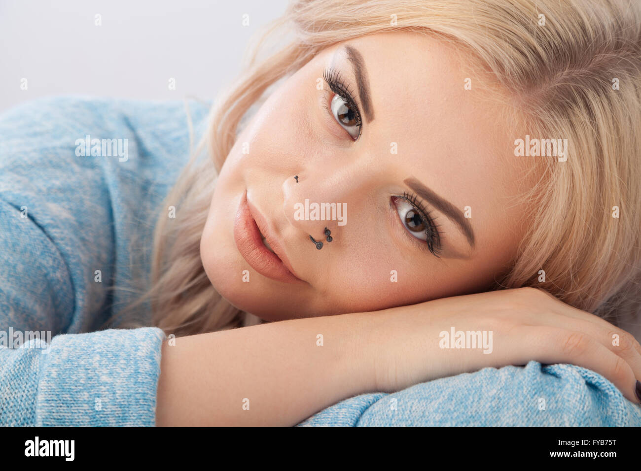Portrait of a pretty fifteen year old girl with her head resting on her arms. Stock Photo