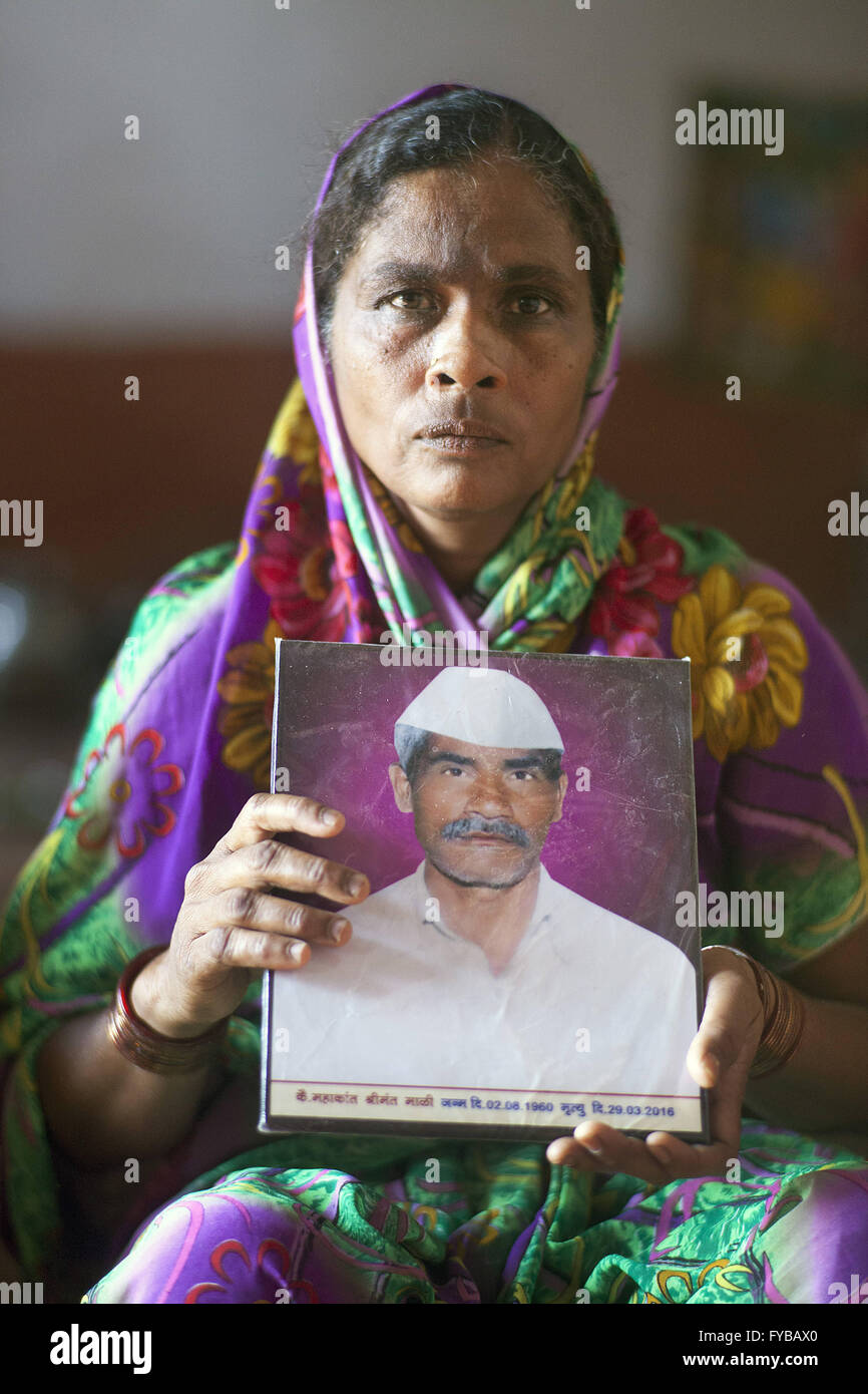 Latur, Maharashtra. 21st Apr, 2016. 21 April 2016 - Gategaon, Latur - INDIA.Kamalbai with a picture of her farmer husband Mahakant Mali, 55, who committed suicide by hanging himself from a dried Mango tree.Latur is part of the state's predominantly agricultural Marathwada region, where 273 farmers committed suicide between January and March this year.The area is among the worst affected by the drought and some families in Latur have left for cities such as the state capital Mumbai, nearly 500 kilometres away. In Latur town, there are huge queues at water storage tanks that are fed from Stock Photo