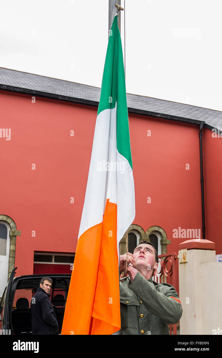 Skibbereen, Ireland. 24th April, 2016. Ian Lynch, direct descendant of rebel fighter Gearóid O'Sullivan, raises the Irish Tricolour during the Mercy Heights School's Proclamation Day event to commemorate 100 years since the start of the rebellion in Dublin. Credit: Andy Gibson/Alamy Live News Stock Photo