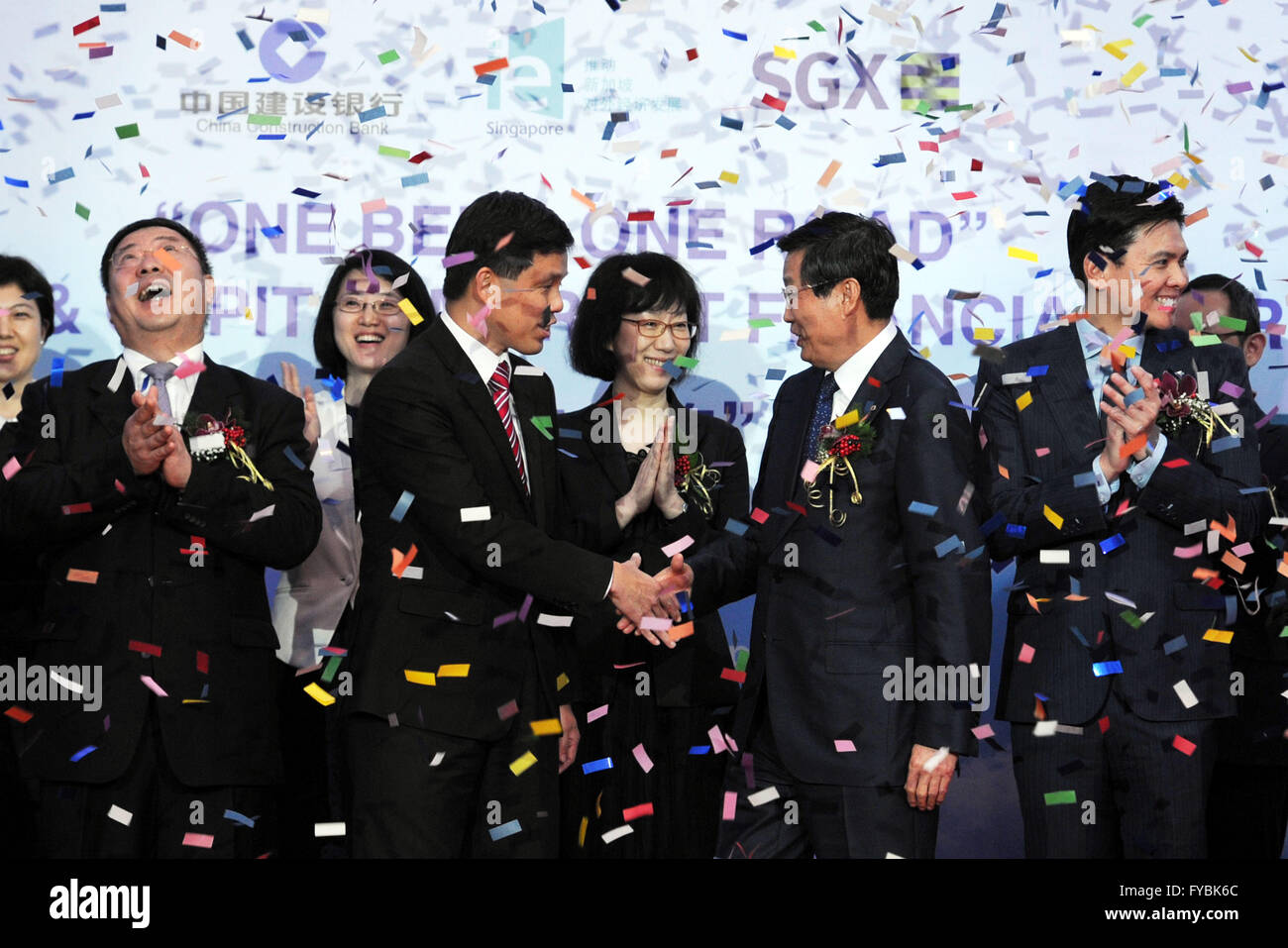 (160425) -- SINGAPORE, April 25, 2016 (Xinhua) -- Singapore's Minister in Prime Minister's Office Chan Chun Sing (L, center) and Chairman of China Construction Bank (CCB) Wang Hongzhang (R, center) shake hands during the signing ceremony of Memorandum of Understanding (MoU) held in Singapore, April 25, 2016. The CCB and International Enterprise (IE) Singapore signed a MOU on Monday, in which CCB will provide 30 billion Singapore dollars (22.2 billion U.S. dollars) of financing services to support enterprises on infrastructure projects under the Belt and Road Initiative. (Xinhua/Then Chih Wey) Stock Photo