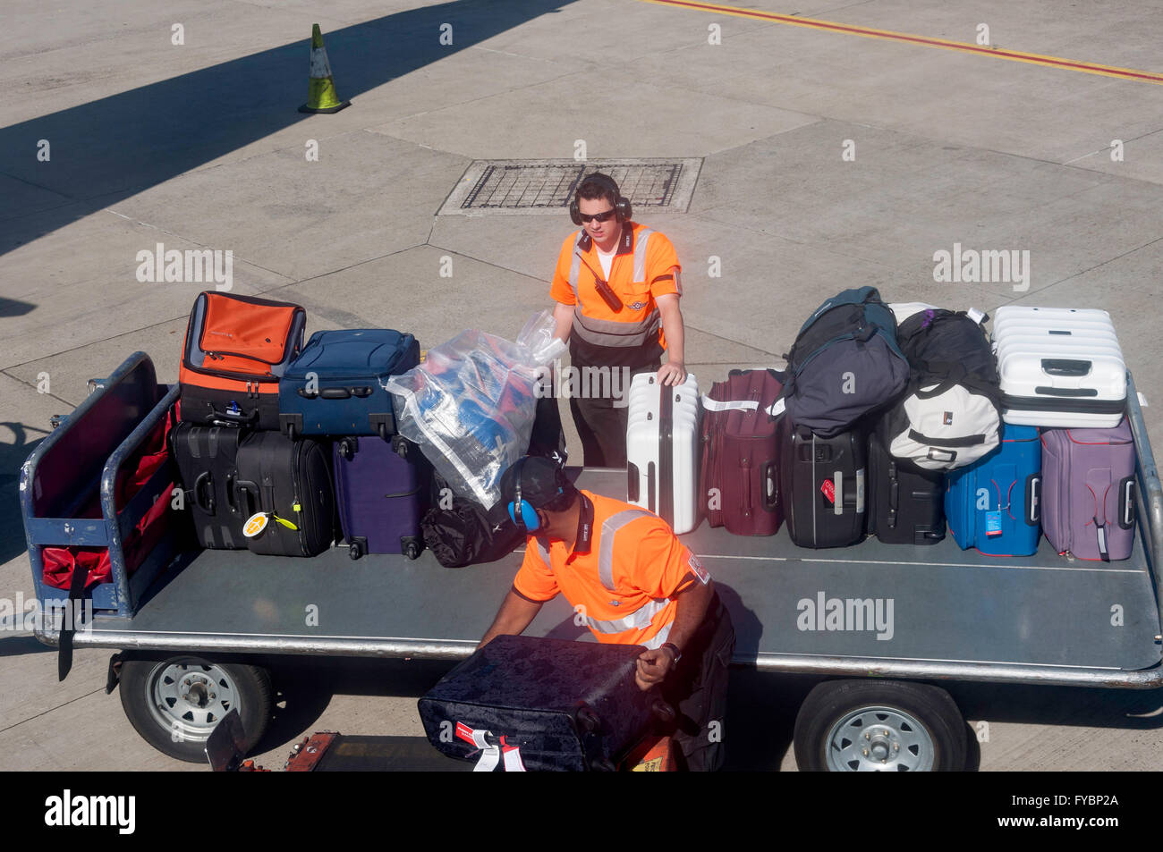 Baggage handlers unloading bags from aircraft at Sydney Kingsford Smith Airport, Mascot, Sydney, New South Wales, Australia Stock Photo