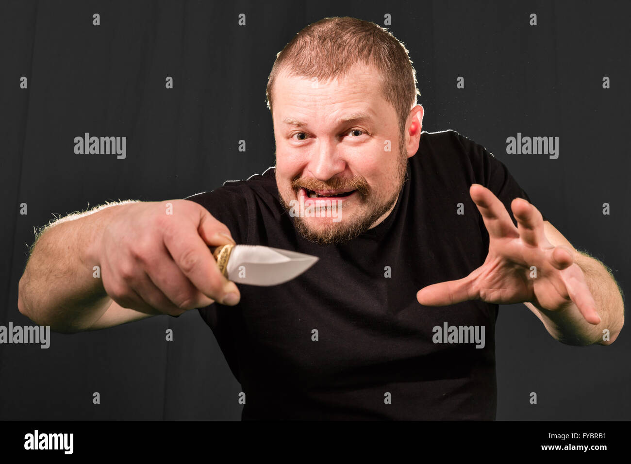Portrait of a gangster with a knife low key Stock Photo - Alamy