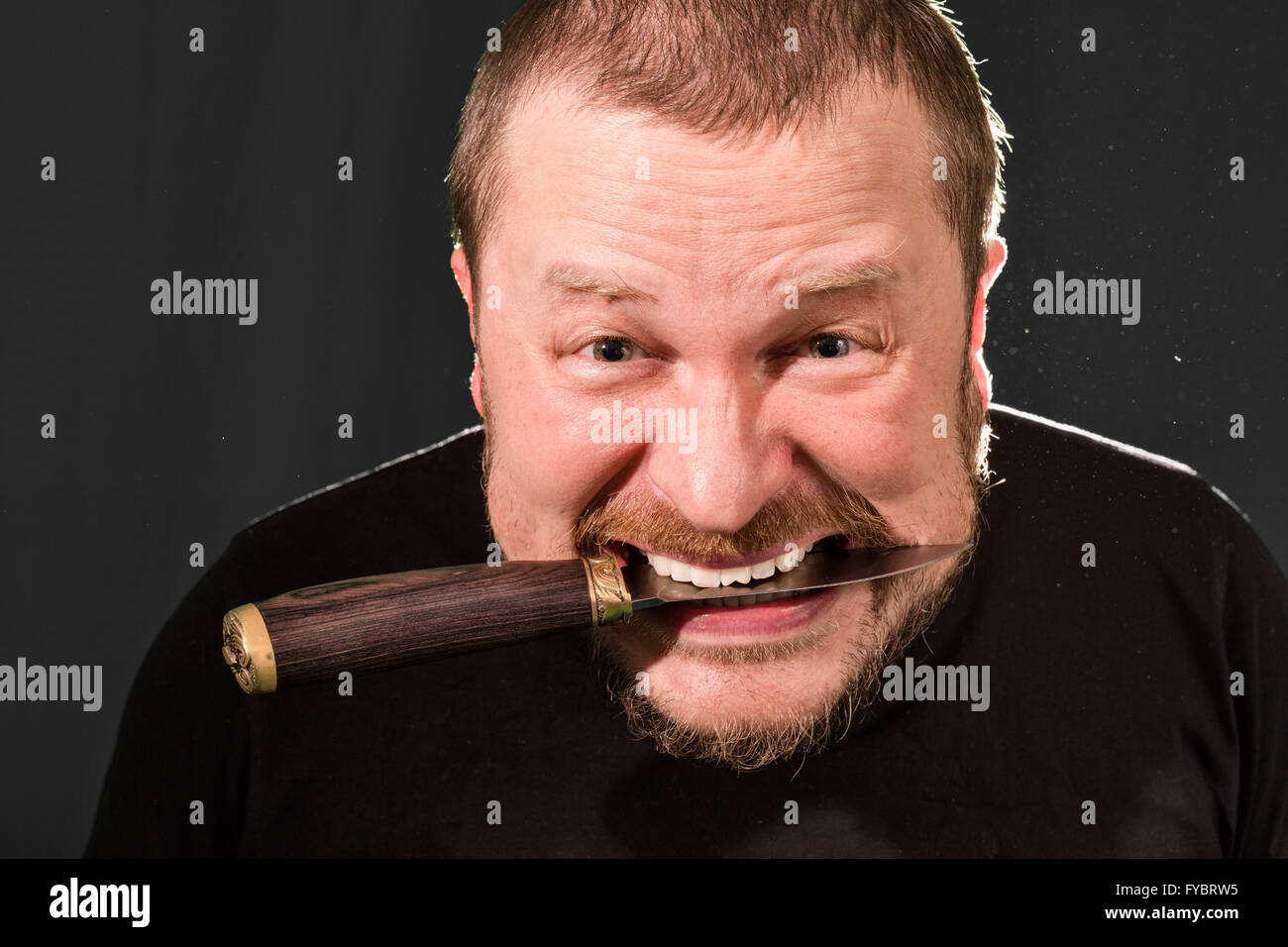 Portrait of a gangster with a knife low key Stock Photo - Alamy