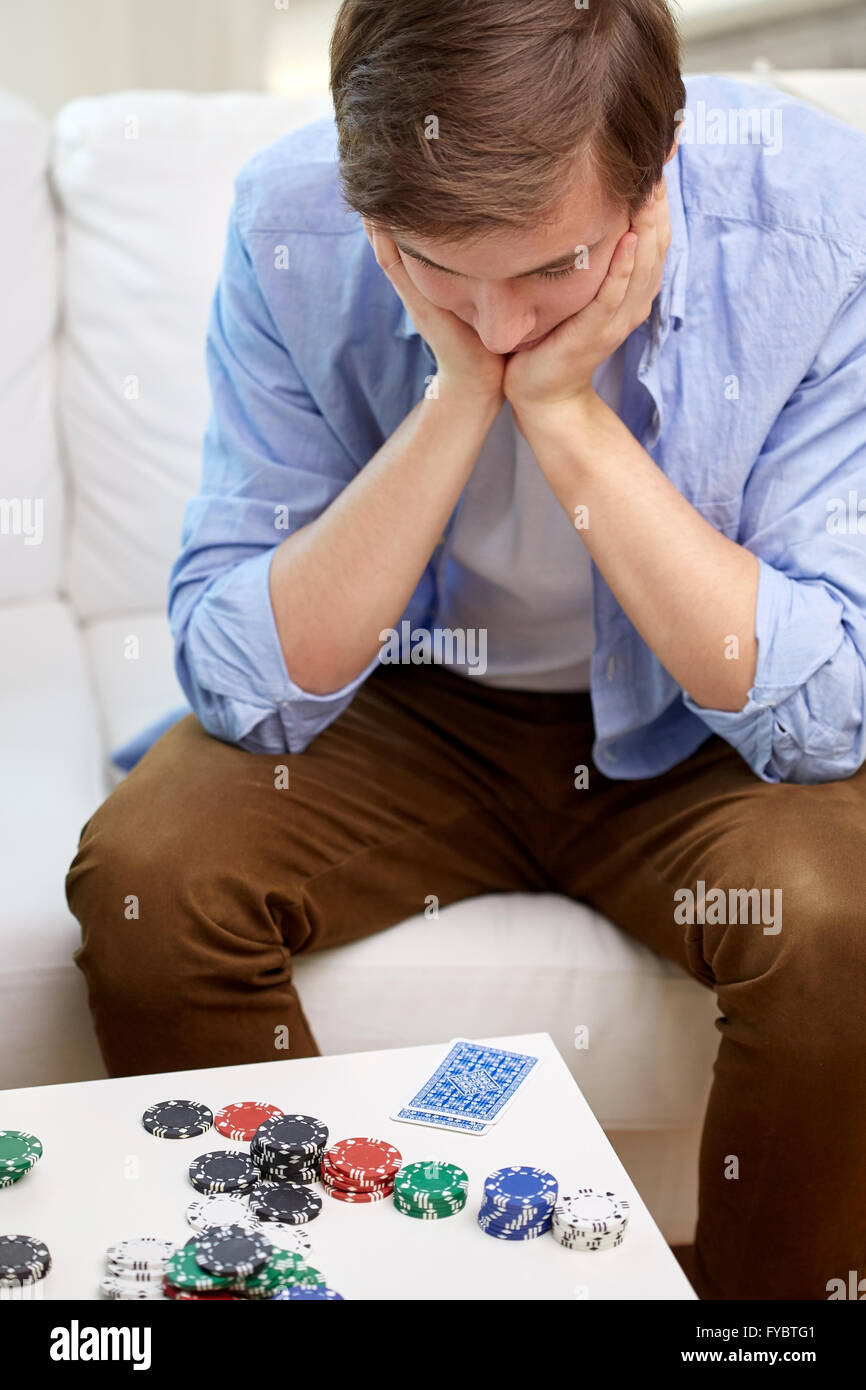 man with playing cards and chips at home Stock Photo