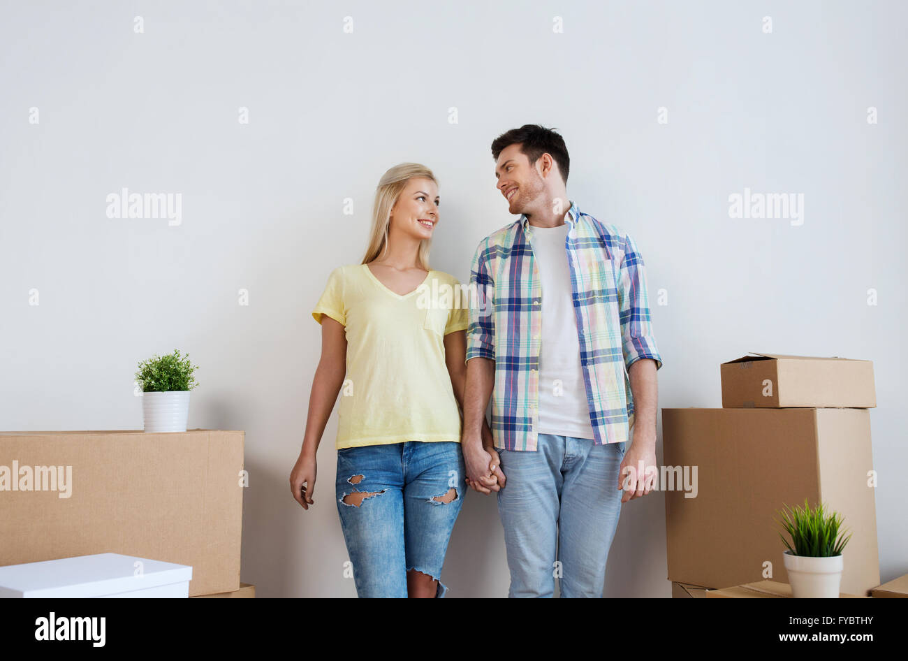 smiling couple with big boxes moving to new home Stock Photo - Alamy