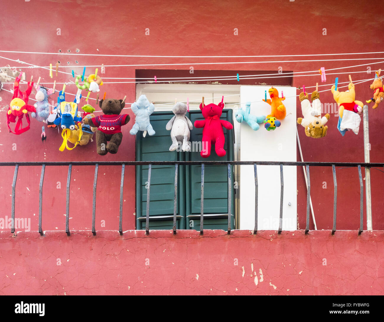 Teddy Bears and cuddly toys on washing line on apartment balcony Stock