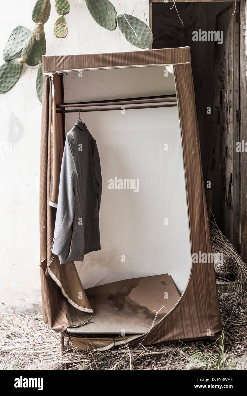 Jacket hanging in wardrobe outside derelict house. Stock Photo