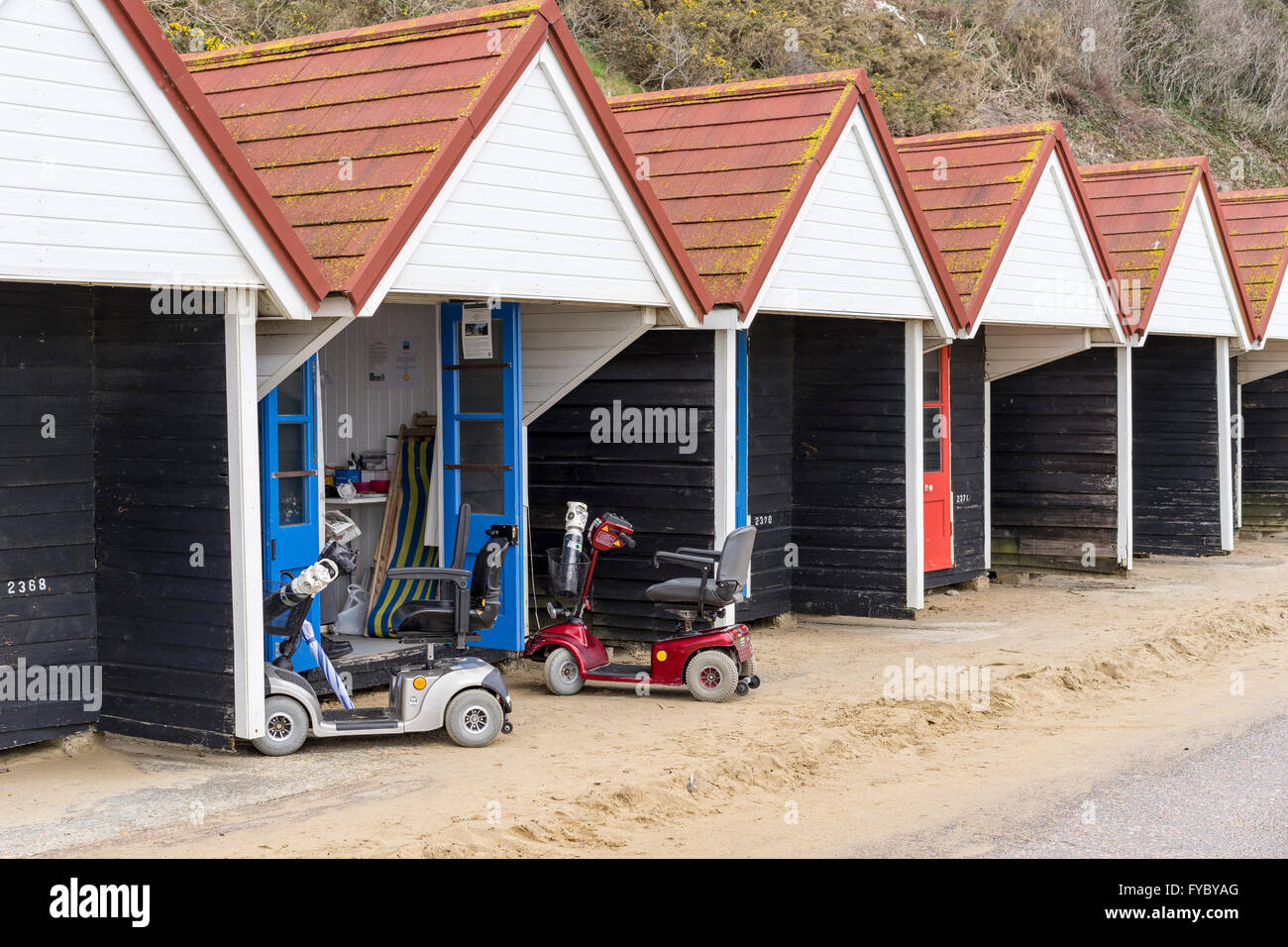 A pair of mobility scooters parked outside a public hire beach hut, Bournemouth, Dorset Stock Photo