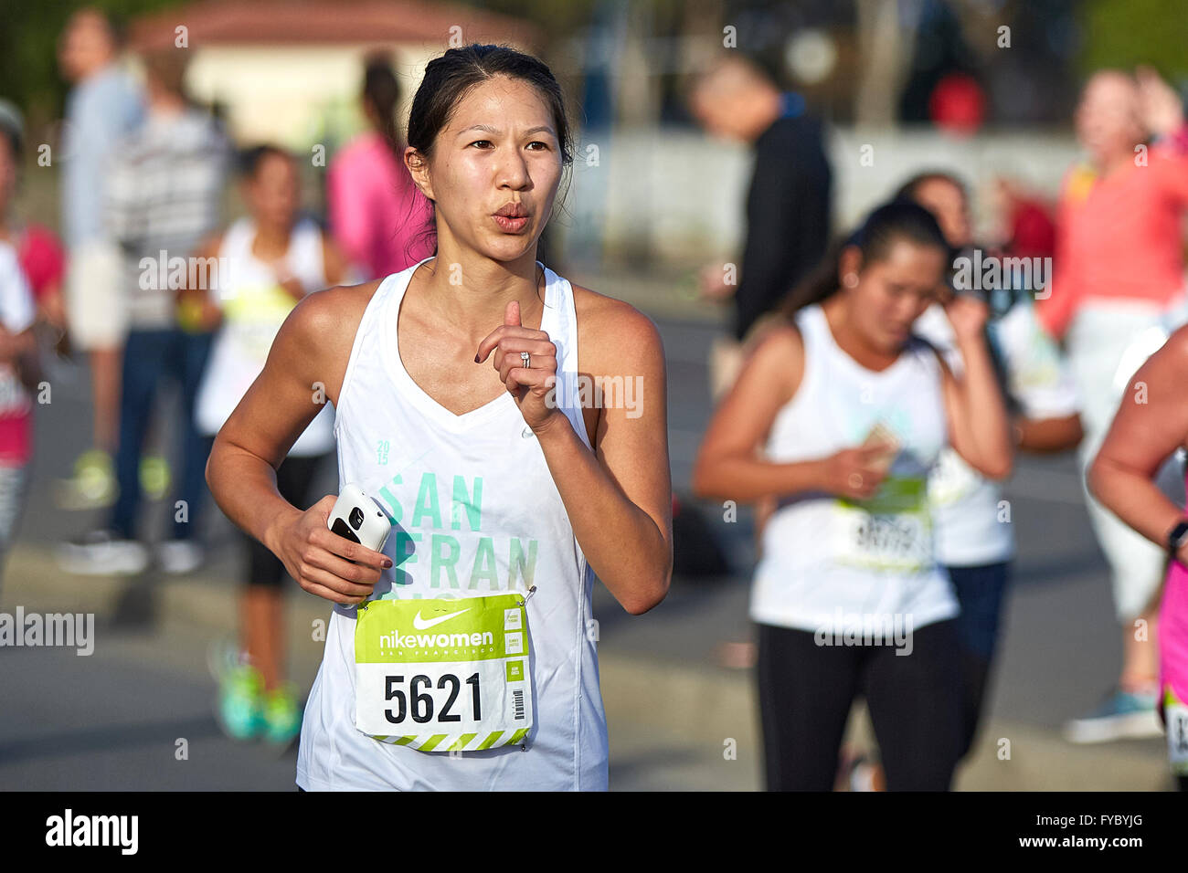Committed Asian Female Athlete Running In The Nike Woman's Half Marathon, San Francisco, 2015. Stock Photo