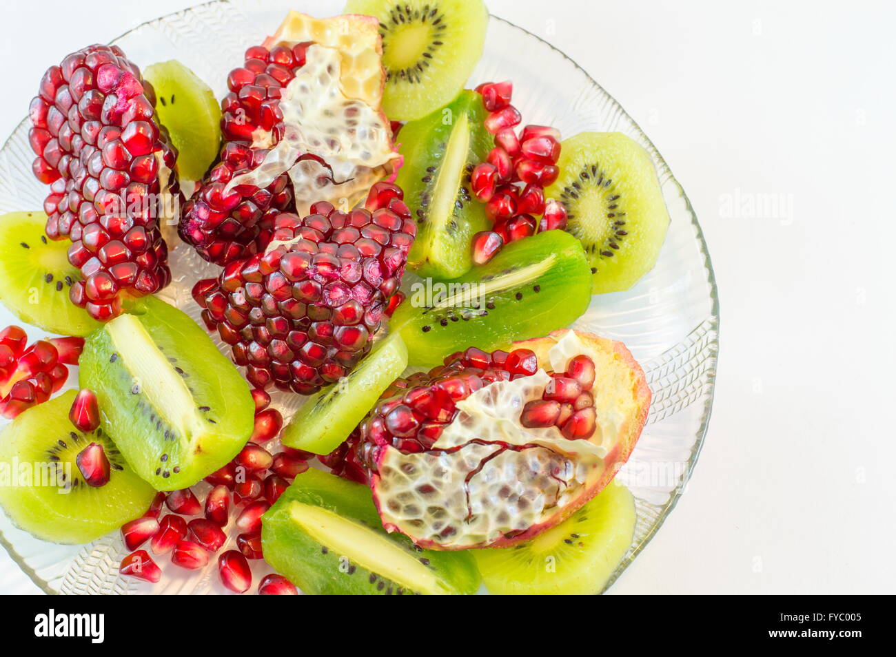 sliced pomegranate and kiwi on a plate Stock Photo