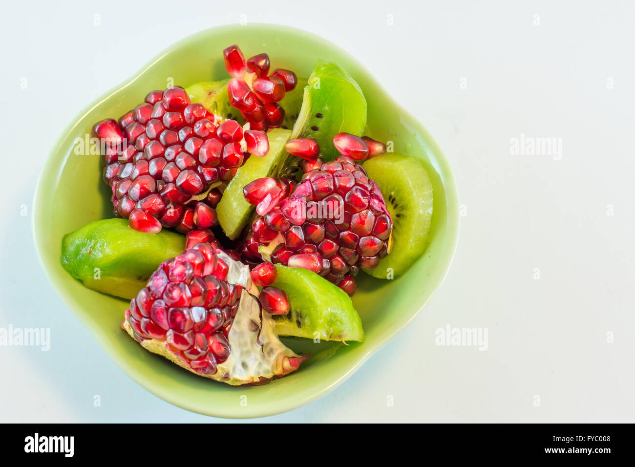 sliced pomegranate and kiwi on a plate Stock Photo