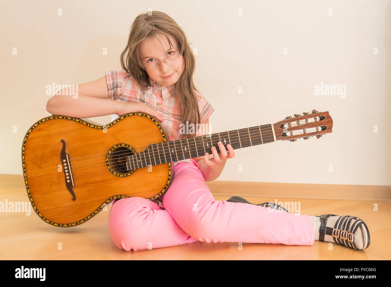 Girl sitting on floor with russian seven-string acoustic guitar Stock Photo