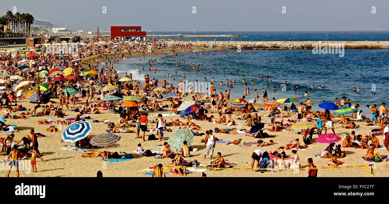 Crowded beach during the summer, filled with colorful umbrellas in