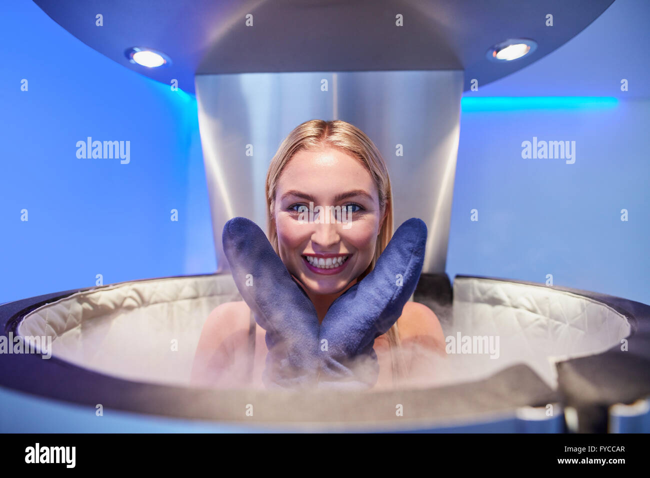 Portrait of a cute young woman in cryosauna booth for full body cryotherapy. Caucasian female in freezing chamber with nitrogen Stock Photo