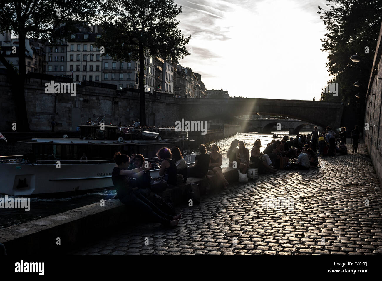 A general view of sunset in Paris where members of the public enjoying talking next to a canal. France. Stock Photo