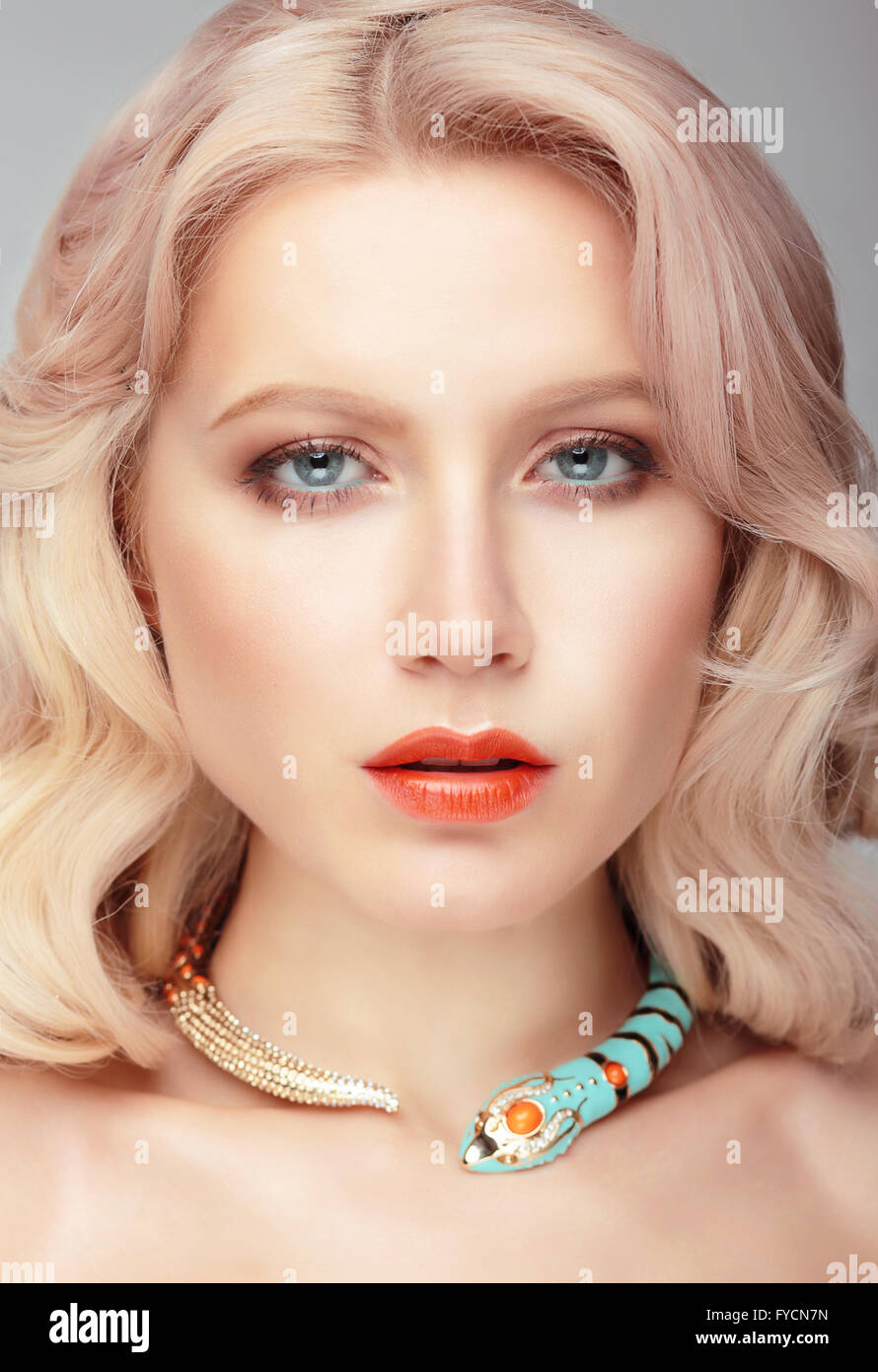 The woman's face with a gentle make-up and jewelry in the form of a snake around her neck. Stock Photo