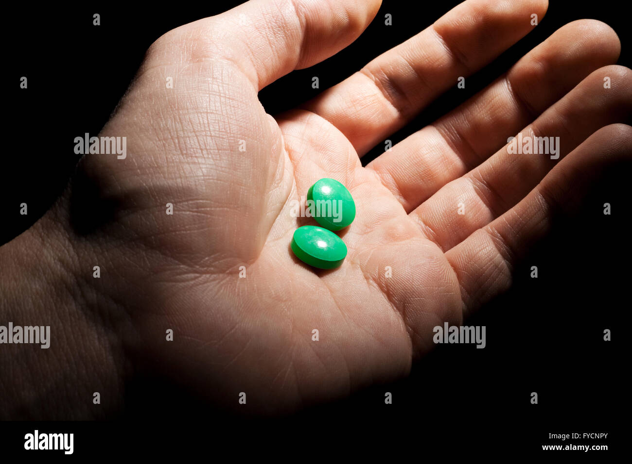 Two green pills on the opened palm Stock Photo