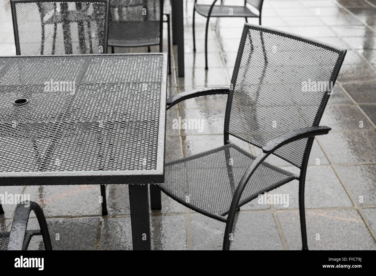 Black wrought iron patio set in the rain Stock Photo Alamy