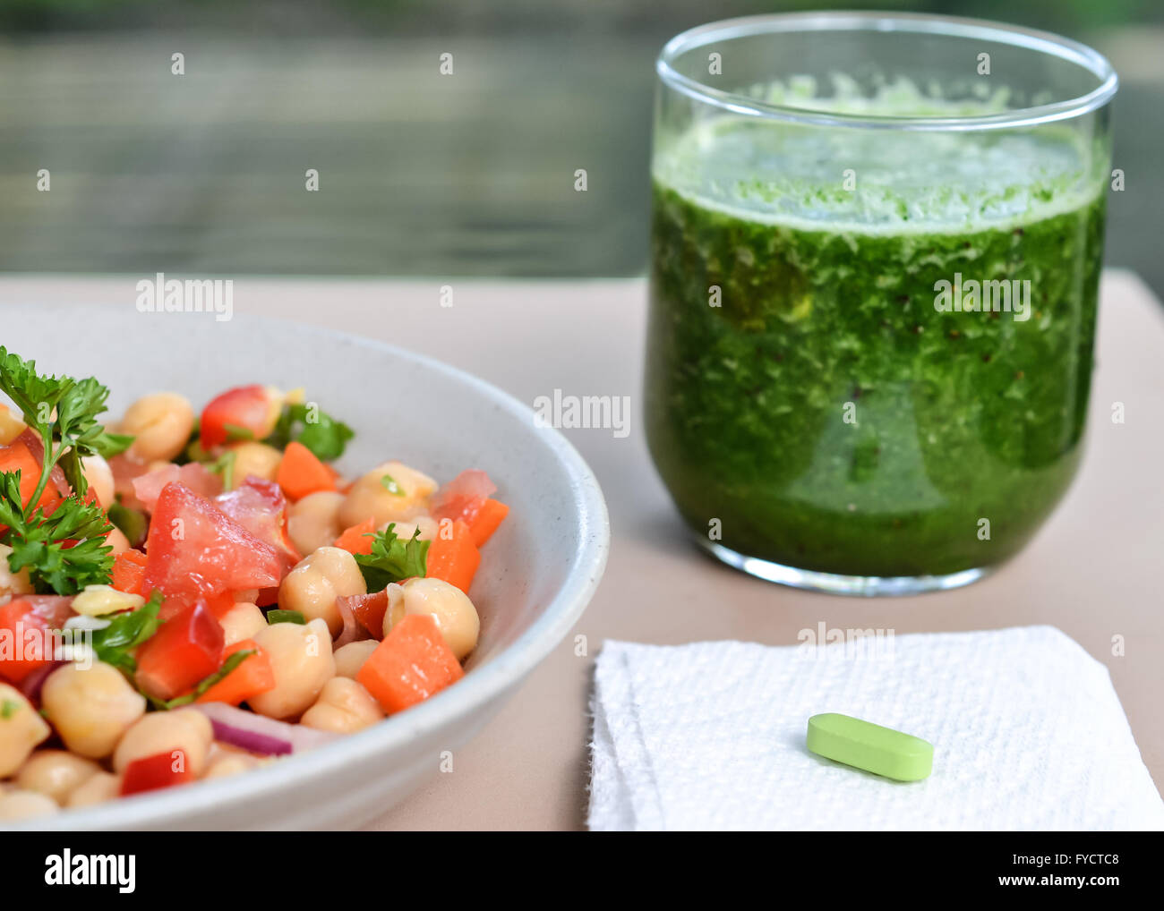 Sources of calcium: garbanzo salad, detox kale smoothie and oyster shell calcium supplement Stock Photo